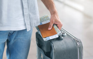 Man Holding His Passport And Carrying Suitcase, Close Up