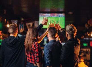 Friends Watches Football On Tv In A Sport Bar