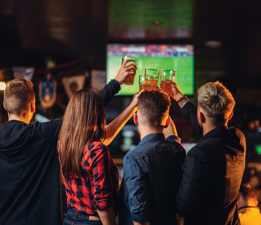 Friends Watches Football On Tv In A Sport Bar