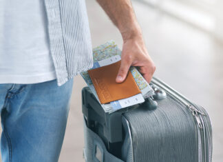 Man Holding His Passport And Carrying Suitcase, Close Up