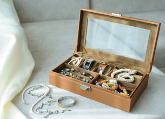 Leather Jewelry Box With Jewelry And Accessories Laid On A Couch