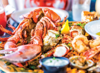 Macro Closeup Of Red Lobsters, Shrimp, Crab, Oyster And Seafood Platter On Plate In Restaurant With Tartar Sauce