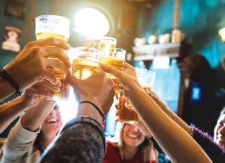 Group Of Happy Friends Drinking And Toasting Beer At Brewery Bar Restaurant Friendship Concept With Young People Having Fun Together At Cool Vintage Pub Focus On Middle Pint Glass High Iso Image