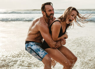 Playful Couple Having Fun On Their Summer Beach Vacation