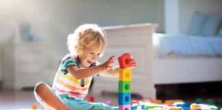 Child Playing With Colorful Toy Blocks. Kids Play.