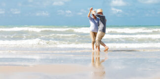 Asian Senior Couple Dancing On The Beach