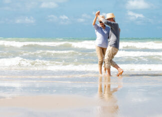 Asian Senior Couple Dancing On The Beach