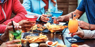 Group Of Friends Enjoying Appetizer Drinking And Eating In A Bar Close Up Of Hands Of Young People Holding Colorful Cocktails In The Happy Hour Time Social Gathering Party Time Concept