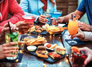 Group Of Friends Enjoying Appetizer Drinking And Eating In A Bar Close Up Of Hands Of Young People Holding Colorful Cocktails In The Happy Hour Time Social Gathering Party Time Concept