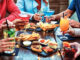 Group Of Friends Enjoying Appetizer Drinking And Eating In A Bar Close Up Of Hands Of Young People Holding Colorful Cocktails In The Happy Hour Time Social Gathering Party Time Concept