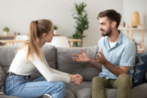 Serious Young Couple Sitting Together, Talking About Relationships