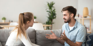 Serious Young Couple Sitting Together, Talking About Relationships