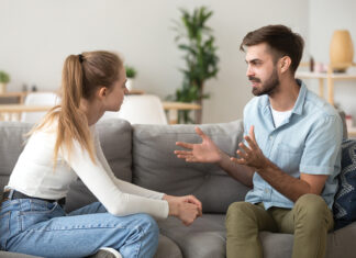 Serious Young Couple Sitting Together, Talking About Relationships