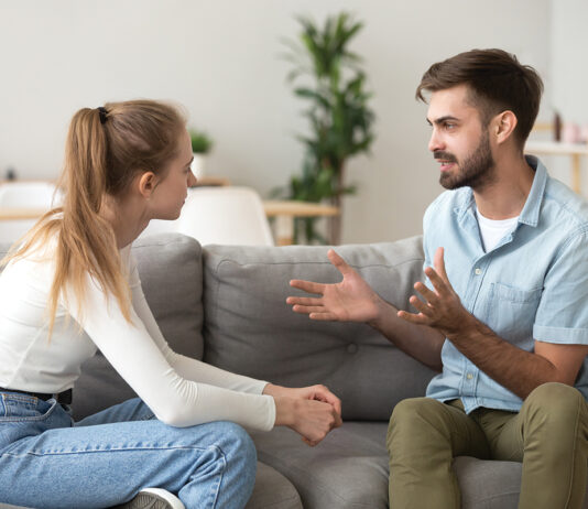 Serious Young Couple Sitting Together, Talking About Relationships