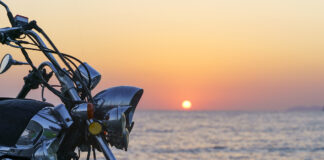 Motorcycle On The Sea Pier During A Beautiful Sea Sunset. Travel, Adventure, Vacation Concept