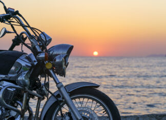 Motorcycle On The Sea Pier During A Beautiful Sea Sunset. Travel, Adventure, Vacation Concept