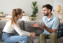 Serious Young Couple Sitting Together, Talking About Relationships