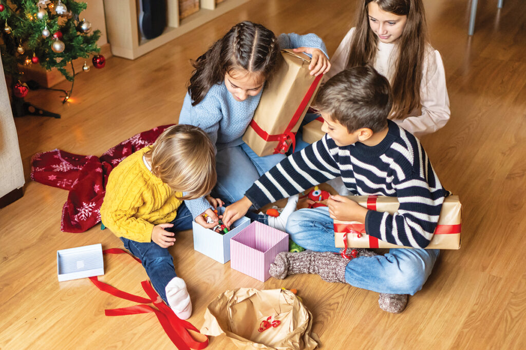 Cheerful Kids Discovering Christmas Presents At Home.