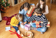 Cheerful Kids Discovering Christmas Presents At Home.