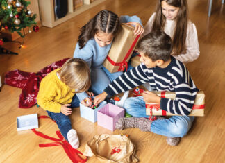 Cheerful Kids Discovering Christmas Presents At Home.