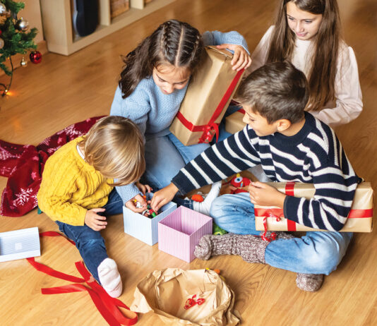 Cheerful Kids Discovering Christmas Presents At Home.