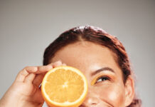 Orange, Beauty And Woman Face In Studio With A Smile For Natural Skin Glow, Cosmetic And Dermatology. Facial Results, Health And Wellness Of Aesthetic Model Person Happy With Vitamin C Fruit Idea